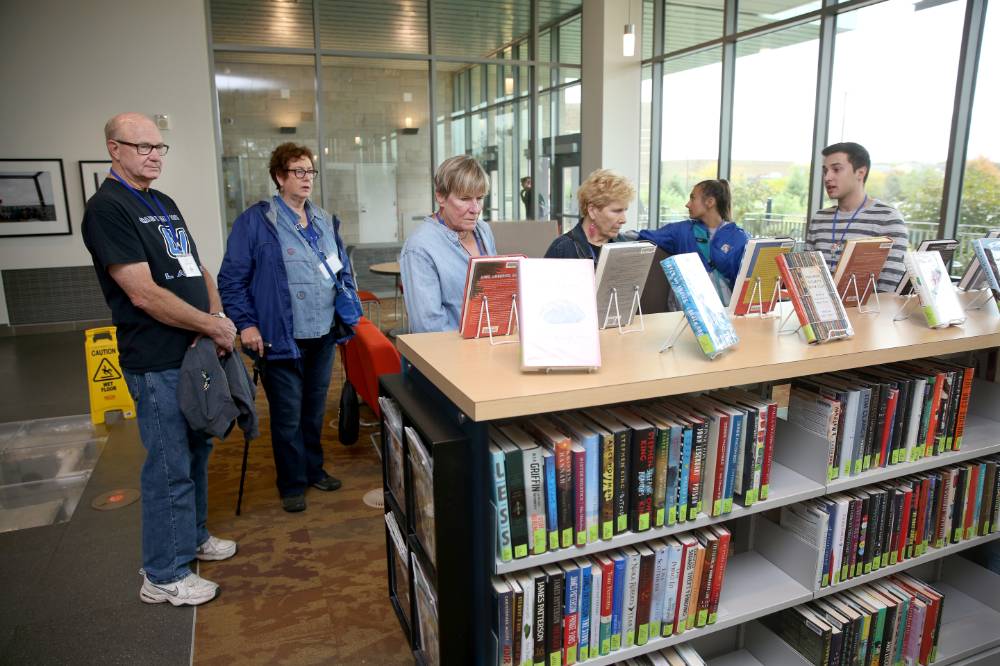 Class of '68 takes a look at the books in the library on the campus tour.